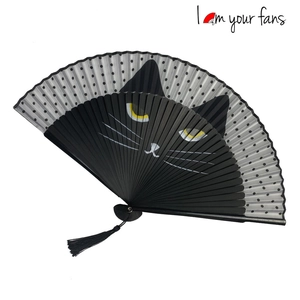 Detail of black cat folding fan with gray polka dots and an elegant black tassel