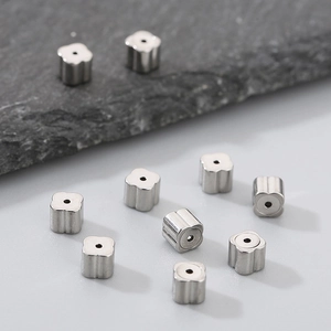 Detailed macro view of clover shaped silver stainless steel beads for DIY jewelry making