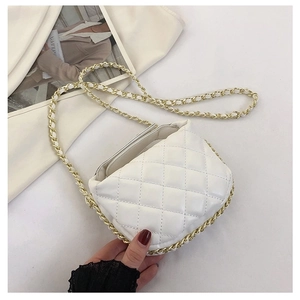 Detailed close-up of white quilted mini chain bag with elegant gold metal strap