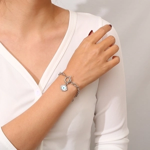 Silver devil eye bracelet with OT buckle closure worn on wrist, chic fashion jewelry