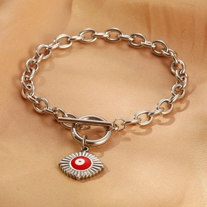 Detail of red Evil Eye charm on a silver chain bracelet with a toggle clasp design