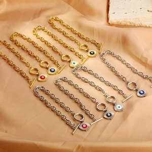 Fashionable 18k gold plated OT buckle evil eye chain bracelets on satin background