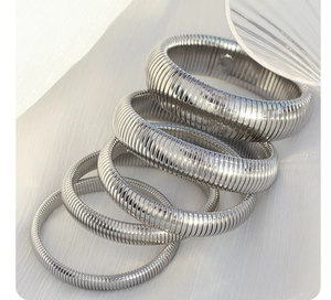 Macro detail of silver stainless steel spring bracelets with various thickness and texture
