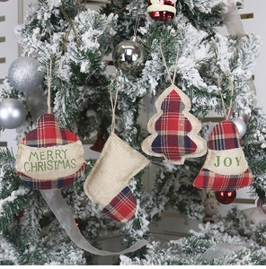 Détail de suspensions de Noël en toile de jute avec broderie sur branches enneigées