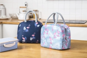Detail of insulated flamingo lunch bags with sturdy handles on a clean kitchen counter