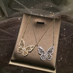 Elegante collana a farfalla traforata con micro-pavé di zirconi in oro e argento