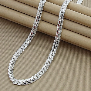 Detailed close-up of 5mm silver cuban link chain texture on a neutral natural background