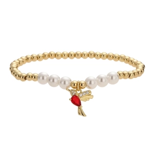 Elegant gold beaded bracelet with white pearls and a hummingbird pendant with red stones