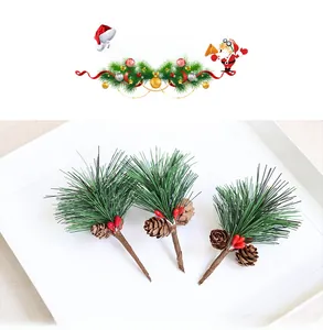 Close-up of three artificial pine branches with red berries and natural pine cones