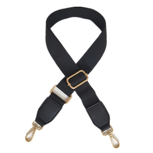 Adjustable black canvas shoulder strap with gold metal hardware for versatile handbags