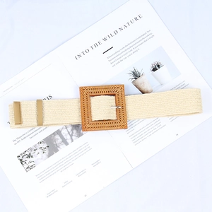 Detail of beige woven belt featuring a square wood-grain buckle on a magazine background