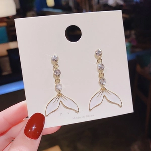 Detail of long mermaid tail dangle earrings with gold alloy and sparkling crystals