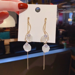 Detail of long tassel earrings with white shell petals and gold metal fringe design