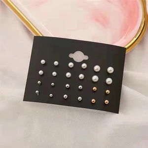 Set of 12 pairs of fashion pearl and metal stud earrings on a black display card