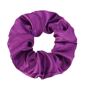 Close-up of a glossy purple satin hair scrunchie with detailed silk texture and folds