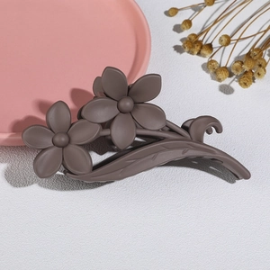 Detail shot of a matte brown flower hair claw with floral and leaf-vein design