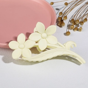 Detailed view of matte cream flower hair claw clip with floral and leaf resin design