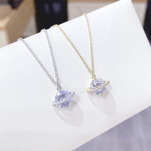 Detailed view of Saturn planet pendant necklaces in gold and silver with sparkling crystals