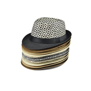 Detailed pile of paper straw fedora hats featuring black ribbon and geometric weave patterns