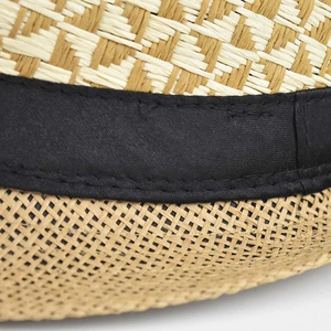 Close-up of linen straw fedora showing fine weave texture and black decorative ribbon detail