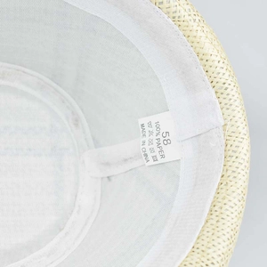 Detail view of linen sun hat interior showing the 100% paper material label and size 58 tag