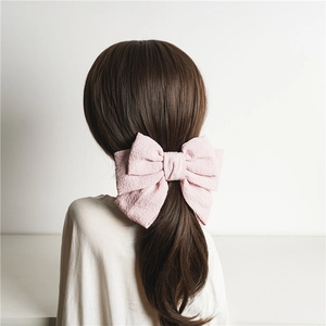 Pink triple-layered large bow hair clip with wrinkled texture shown from the back view