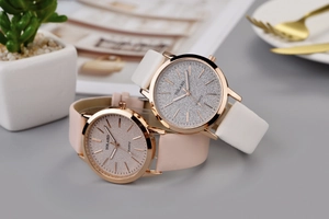 Makroaufnahme modischer Uhren mit Glitzerzifferblatt und Lederarmbändern auf Marmor