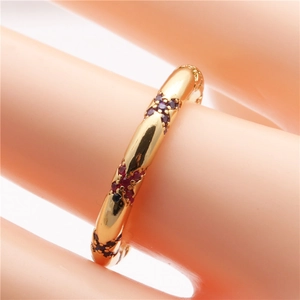 Detailed view of bohemian gold open ring featuring red crystal eye design in X-shape pattern