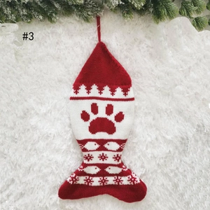 Detailed close-up of fish-shaped knit Christmas stocking with red paw pattern