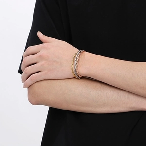 Detailed view of twisted rope texture bangles in gold, silver and rose gold metal finish