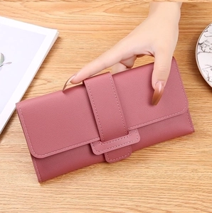 Close-up of pink tri-fold faux leather wallet with cross-pattern texture and snap closure
