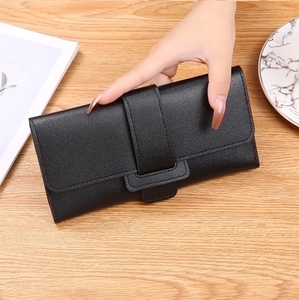 Detailed view of women's long black trifold wallet with lychee pattern leather and metal snap
