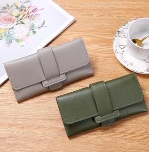 Detailed view of textured lychee grain leather wallets in grey and dark green colors