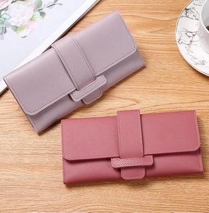 Detail of elegant long flap wallets in lavender and rose pink with litchi grain texture