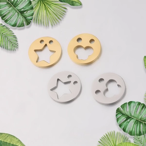 Detail of four circular gold and silver steel charms with star and paw hollow designs