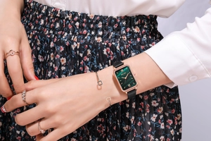 Close-up of elegant malachite green dial rectangular watch with rose gold case