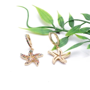 Golden starfish hoop earrings with colorful zircon stones on a white background