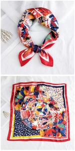 Detail view of red floral silk scarf with abstract patterns and elegant satin finish