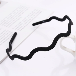 Detail of matte black wavy headband with non-slip teeth for secure styling