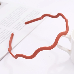 Detail of matte wavy headband in Morandi orange with non-slip tooth design