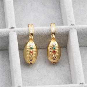 Golden rugby earrings with colorful crystals on a gray velvet jewelry tray