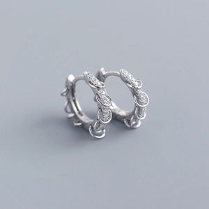 Macro detail of S925 sterling silver hoop earrings with pavé zircons and dangling rings