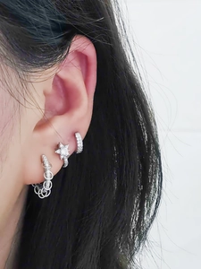 Close-up of S925 sterling silver hoop earrings set with crystal star stud on ear