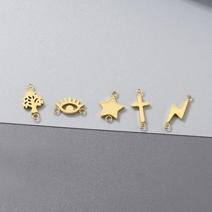 Detailed view of five gold stainless steel charms including star and cross for DIY jewelry