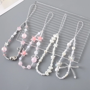 Detail view of 4-piece set beaded phone straps with pink flowers and white heart charms