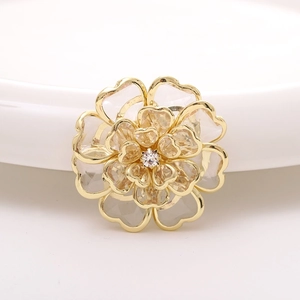 Macro detail of champagne acrylic flower accessory with golden finish and clear rhinestone