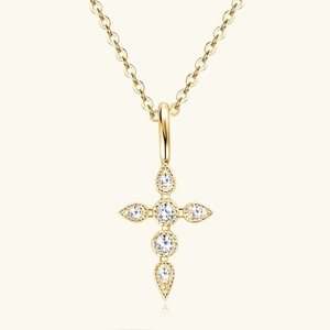 Detailed close-up of a gold cross pendant necklace with sparkling white gemstones