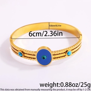 Macro detail of gold evil eye bangle showing blue enamel center and precise dimensions