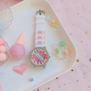 Close-up of pink heart dial watch with candy props and soft pastel background