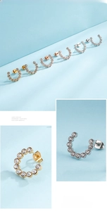 Detailed view of C-shaped hoop earrings with inlaid clear zircons in gold and silver plating